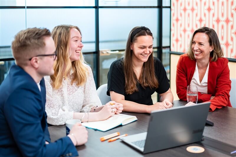 Four employees sat around a meeting table