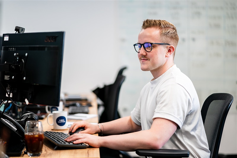 Man typing on computer in bright office
